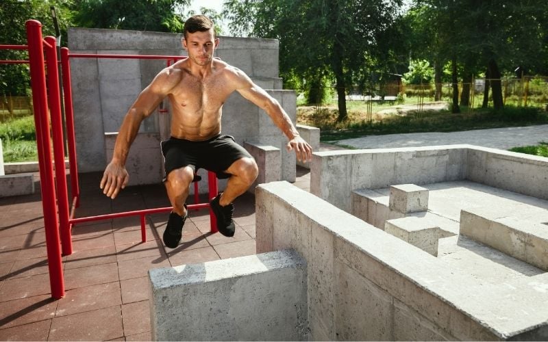 Young and sporty man doing box jumps outdoors